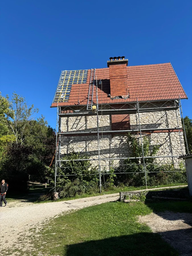 Échafaudage complet monté autour d'une maison de caractère avant la réfection de sa toiture