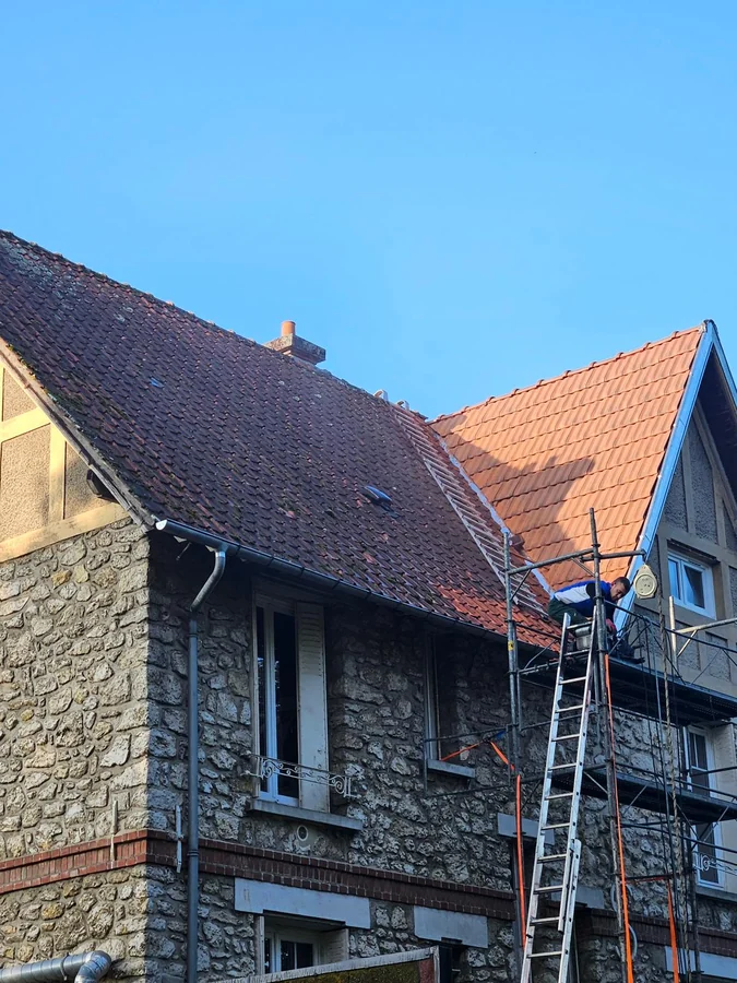 Maison en pierre. Échafaudage monté, toiture en cours de reprise.